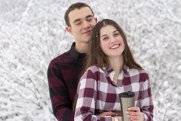 Le gars et la fille se reposent dans les bois d'hiver Mari et femme dans la neige Jeune couple