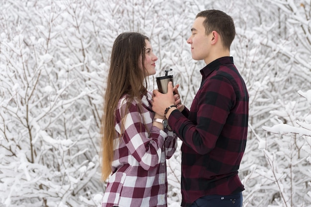 Le gars et la fille se reposent dans les bois d'hiver Mari et femme dans la neige