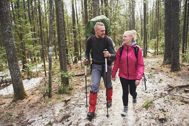 Photo le gars et la fille de touristes parcourent les bois