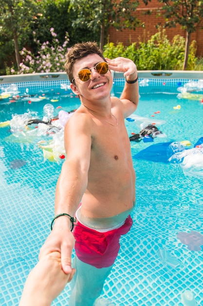 un gars mène dans une piscine avec des ordures.