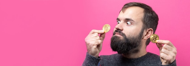 Un gars pensif avec une barbe sur fond rose Penser à l'expression pensive de la question