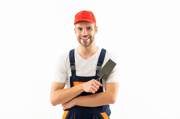 Un gars planifie des travaux de rénovation en plâtre avec une spatule un plâtrier heureux tient une truelle