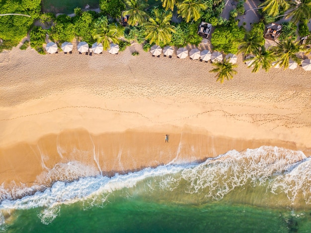 Le gars se trouve sur une plage de sable sur une île tropicale Vue Drone