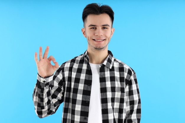 Gars séduisant en chemise sur fond bleu