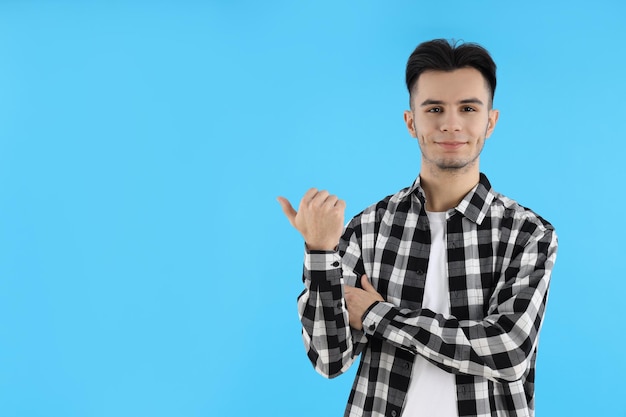 Gars séduisant en chemise sur fond bleu