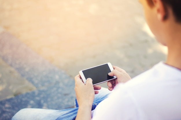 Le gars tient un smartphone mobile et regarde l&#39;écran. dépendance téléphonique