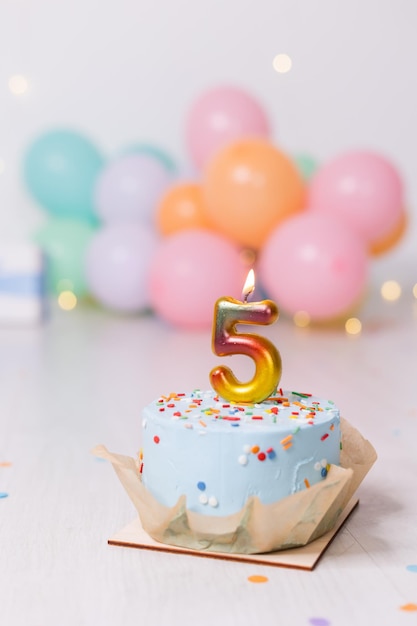 Gâteau d'anniversaire avec bougie cinq ballons joyeux anniversaire