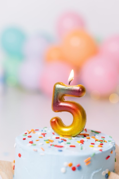 Gâteau d'anniversaire avec bougie cinq ballons joyeux anniversaire