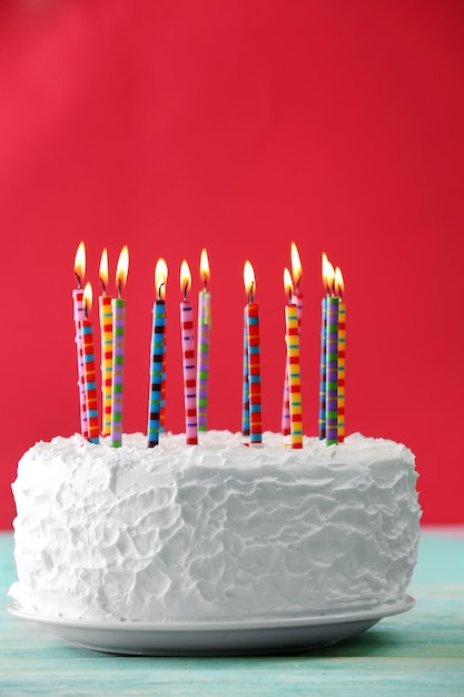 Gâteau d&#39;anniversaire avec des bougies sur fond de couleur