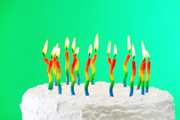 Gâteau d&#39;anniversaire avec des bougies sur fond de couleur