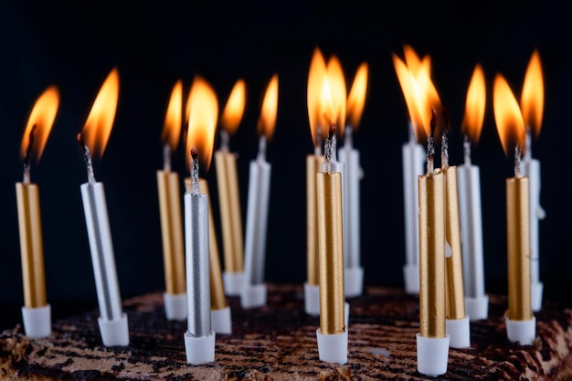 Gâteau d'anniversaire avec des bougies sur fond noir