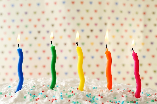 Gâteau d'anniversaire avec des bougies sur fond de points colorés