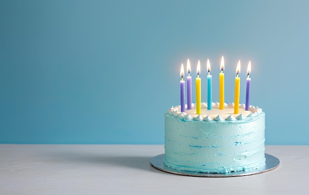 Un gâteau d'anniversaire de célébration et sept bougies d'aniversaire colorées à fond bleu.