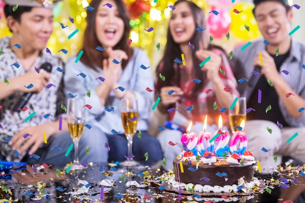 Un gâteau d'anniversaire avec un fond de gens heureux flou