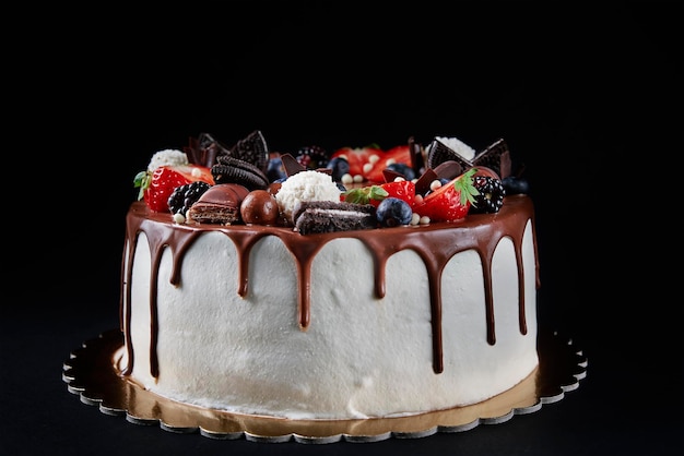 Gâteau d'anniversaire sur fond sombre avec copie espace gros plan de gâteau décoré de baies fraîches et c