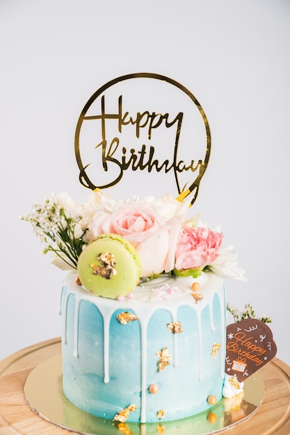 Gâteau d'anniversaire ou gâteau de mariage avec des fleurs, gâteau joyeux anniversaire avec macaron et fleur