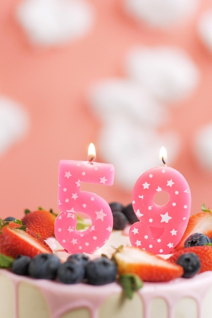 Gâteau d'anniversaire numéro 59 Belle bougie rose en gâteau sur fond rose avec des nuages blancs Gros plan et vue verticale