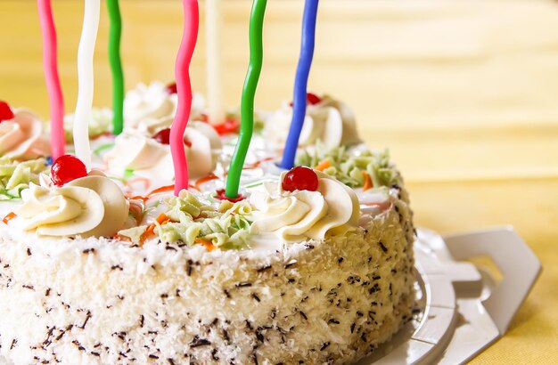 Gâteau d'anniversaire sucré traditionnel avec des bougies colorées.