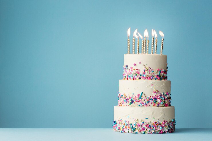 Photo un gâteau d'anniversaire à trois niveaux et des éclaboussures colorées