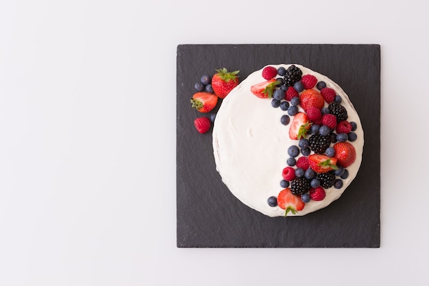 gâteau d'anniversaire à la vanille fait maison décoré de baies fraises myrtilles framboises à bord