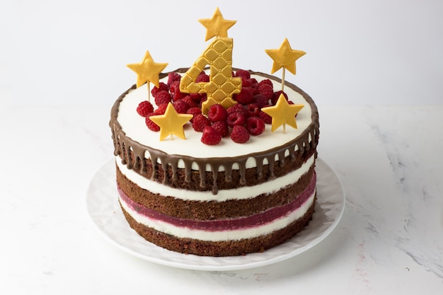 Gâteau d'anniversaire velours rouge avec étoiles d'or et numéro quatre et framboises