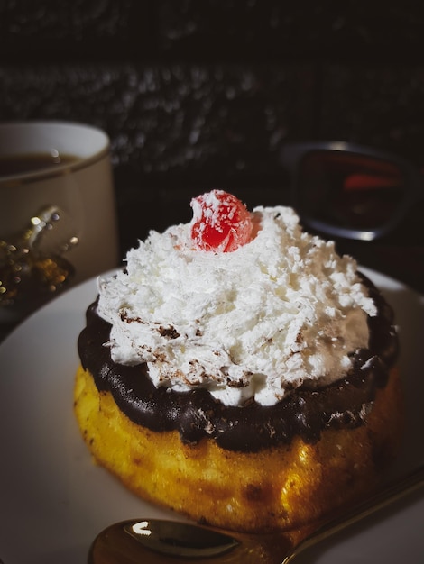 Gâteau appétissant avec crème au chocolat et pâte décorée de cerises fond noir pâte copie espace