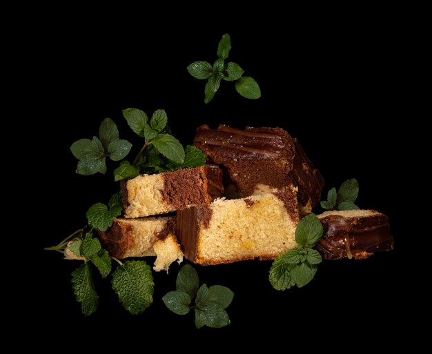 gâteau au biscuit au chocolat au miel coupé en portions avec des feuilles de menthe sur un motif noir