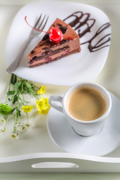 Gâteau au café et au chocolat avec des cerises sur une table en bois