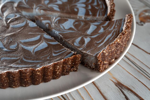 Gâteau au chocolat aux noix posé sur une assiette Pièce magnifiquement coupée Fond brossé en bois