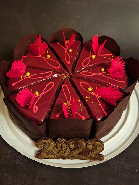 gâteau au chocolat avec de belles décorations rouges se bouchent. Numéros comestibles 2022. Nouvel an.