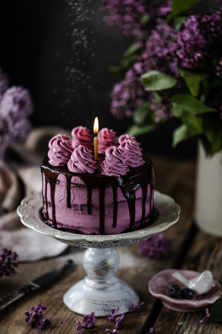 Photo gâteau au chocolat et un bouquet de lilas sur table en bois