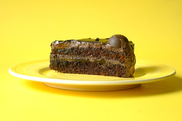 Gâteau au chocolat et à la crème sur une assiette sur fond jaune