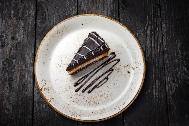 gâteau au chocolat avec de la crème sur un fond en bois