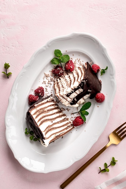 Un gâteau au chocolat à la crêpe avec des framboises fraîches sur un fond rose