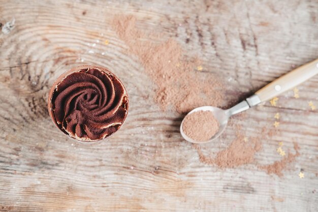 Gâteau au chocolat dans une tasse sur un fond en bois, vue de dessus. bagatelle à la crème au chocolat