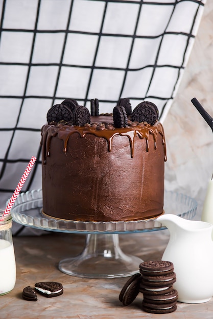 Gâteau au chocolat décoré de biscuits sur un support en verre