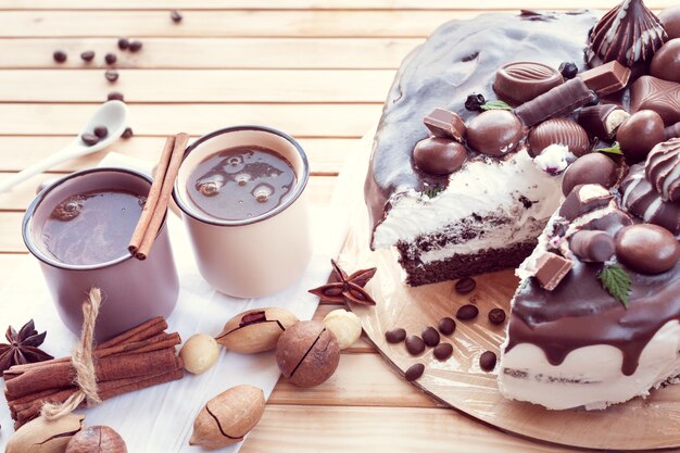 Gâteau au chocolat décoré de chocolats aux noix de macadamia et deux tasses de café