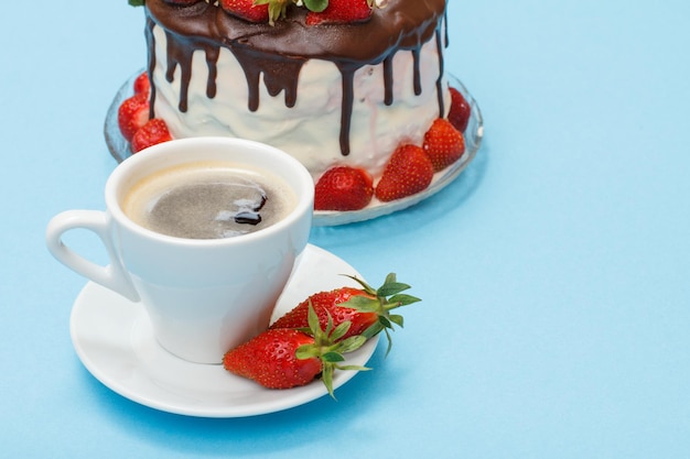 Gâteau au chocolat fait maison décoré de fraises fraîches et d'une tasse de café