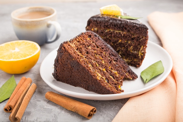 Gâteau au chocolat fait maison à l'orange et à la cannelle avec une tasse de café sur un fond de béton gris. vue latérale, mise au point sélective.