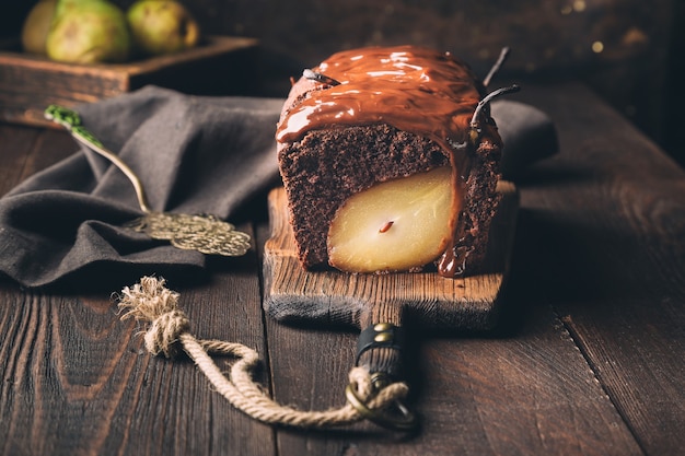 Gâteau au chocolat fait maison avec poire à la surface en bois rustique. Brownie au fudge.