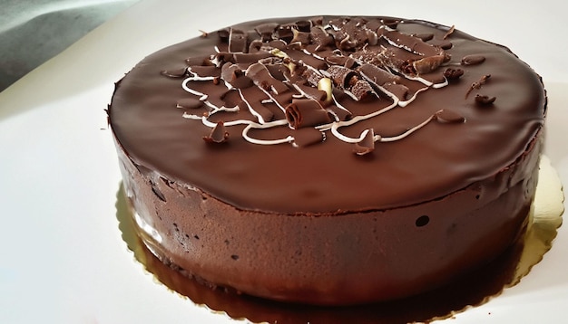 Un gâteau au chocolat avec un glaçage au chocolat blanc et des copeaux de chocolat.