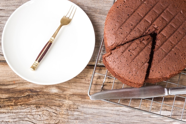 Gâteau au chocolat sur une grille sur une table en bois. Vue de dessus