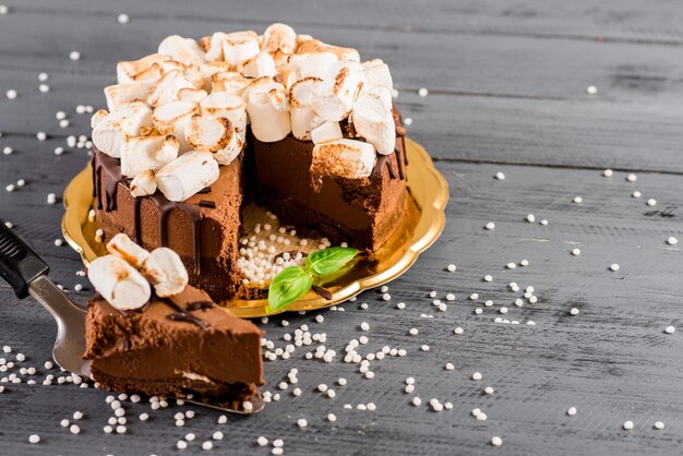 Un gâteau au chocolat avec des guimauves sur le fond en bois