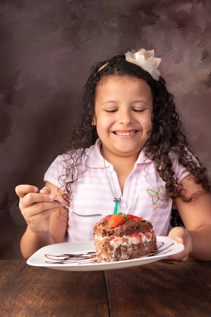 Gâteau au chocolat, jolie fille avec un beau morceau de gâteau au chocolat aux fraises, mise au point sélective.