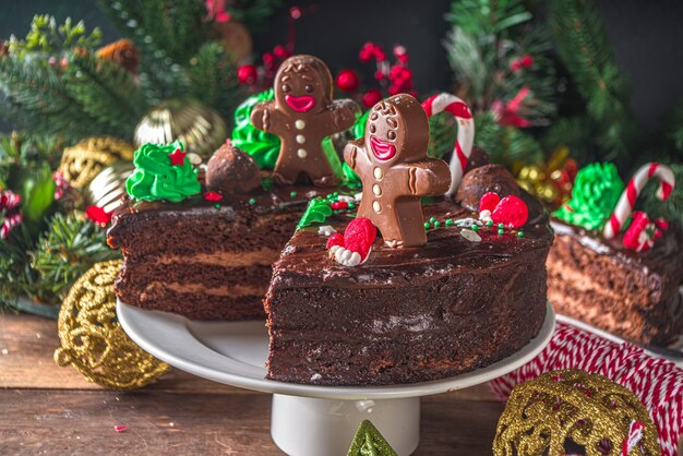 Gâteau au chocolat de Noël. Gâteau au chocolat au pain d'épice fait maison avec décor de sucre et de chocolat sous forme de symboles traditionnels de Noël - canne en bonbon, bonhomme en pain d'épice, arbre de Noël,