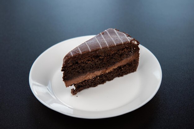 Gâteau au chocolat sur plaque blanche sur fond noir