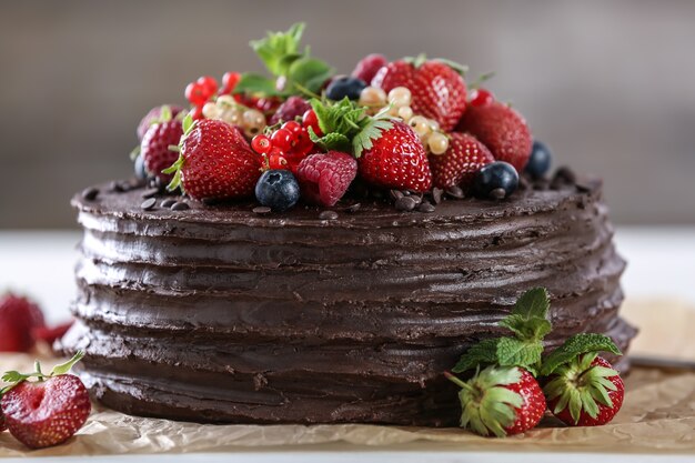 Gâteau au chocolat savoureux décoré de baies sur la table