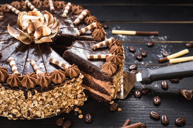 Gâteau au chocolat sucré avec de la crème savoureuse sur le fond en bois noir