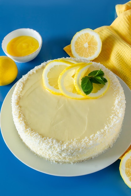 Gâteau au citron avec des flocons de noix de coco sur fond bleu Dessert délicat à la crème