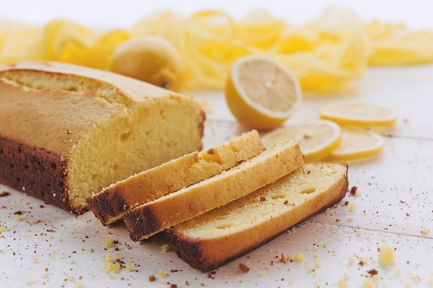 Gâteau au citron avec des fruits sur une surface en bois blanche